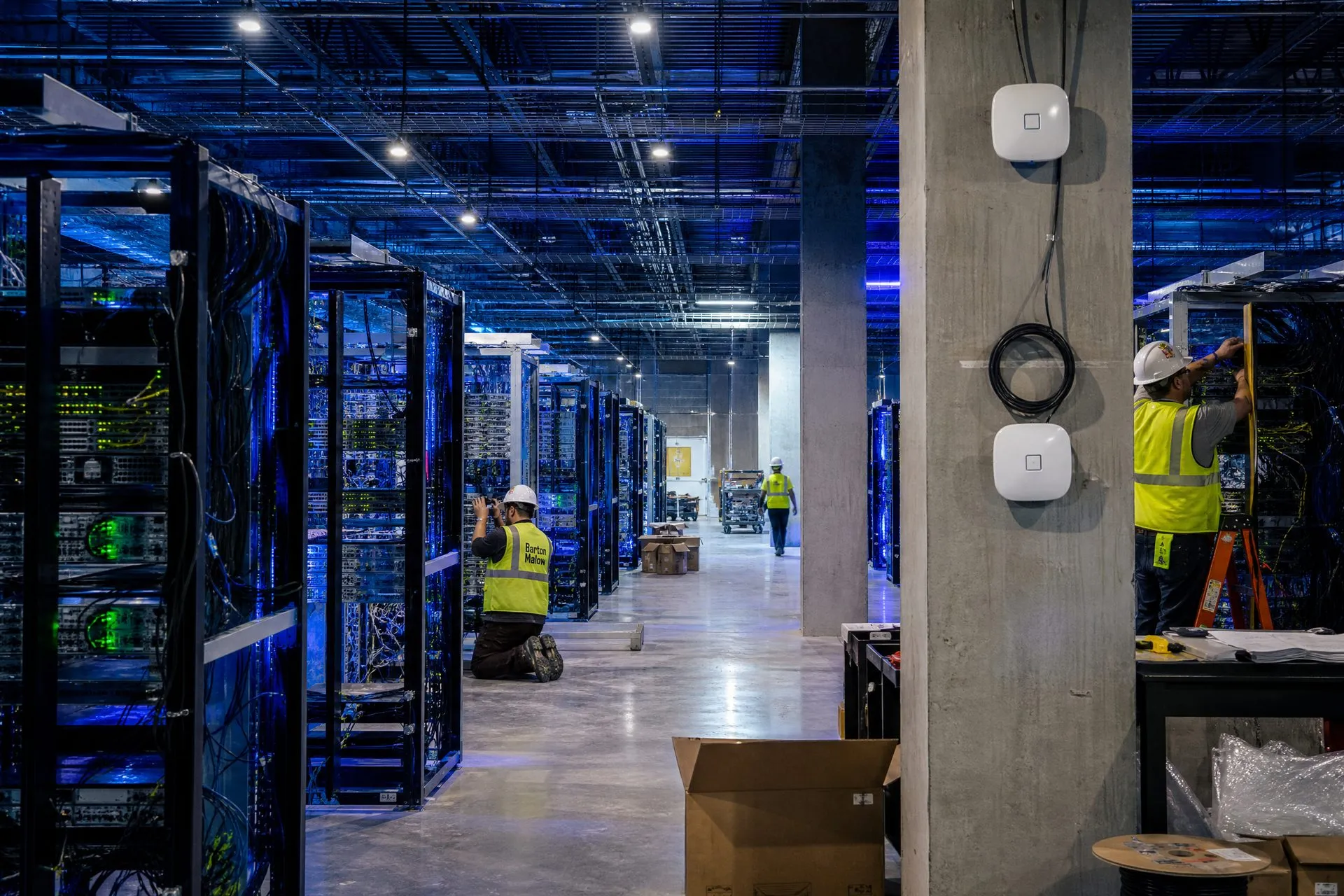 Inside a data center under construction with workers installing network